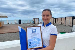Начальник пляжа «Роза Хутор» Кристина Вексельберг с сертификатом «Голубой флаг» © Фото Ирины Сизовой