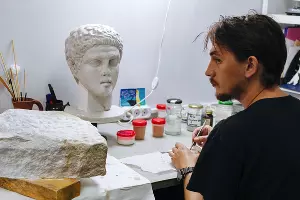 Художник-реставратор Никита Эскандеров и пластиковая копия головы юноши. Оригинал нашли в подводной части фанагорийских раскопок, сейчас он находится в сочинском филиале музея &copy;&nbsp;Фото Юли Шафаростовой, Юга.ру