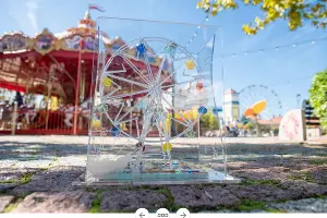 Статуэтка за победу в конкурсе «Хрустальное колесо-2023» на фоне аттракционов «Сочи Парка» &copy;&nbsp;Скриншот новости на сатйе администрации Краснодарского края, Admkrai.krasnodar.ru